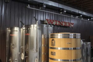 Original location winery sign, stainless steel fermenters, & oak Foeder aging vessel